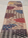 A long rectangular area rug with a multicolor geometric and tribal pattern, handmade Moroccan Berber rug from Taznakht, bohemian living room